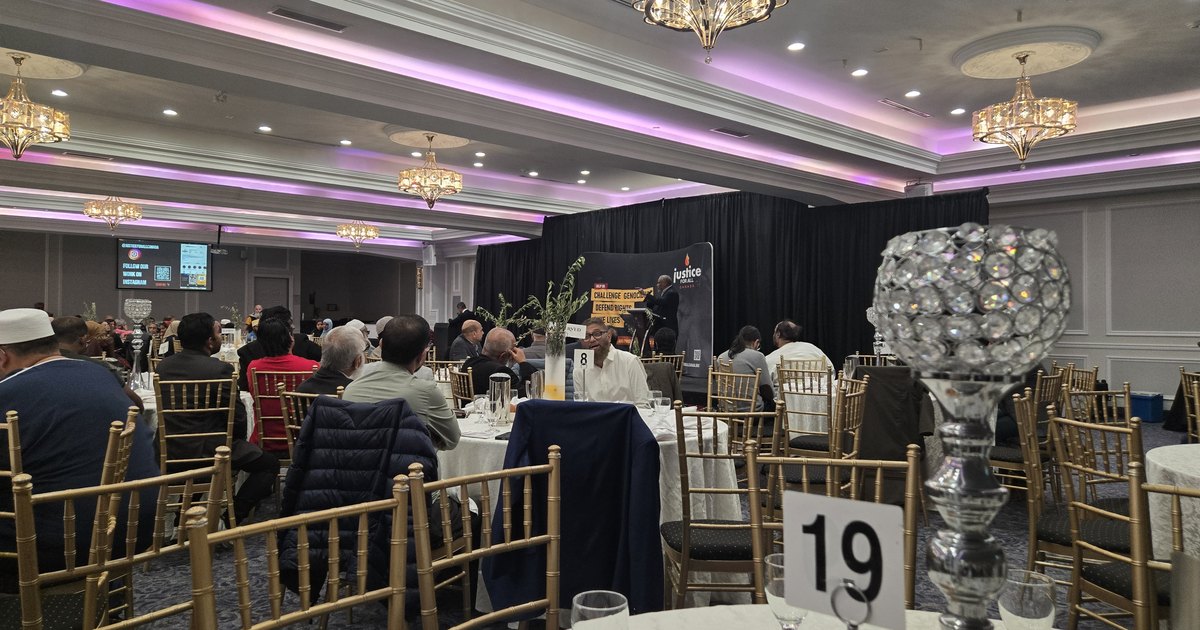 A full ballroom of seated guests facing the stage and screen at Justice For All Canada's Love Ummah event in Toronto