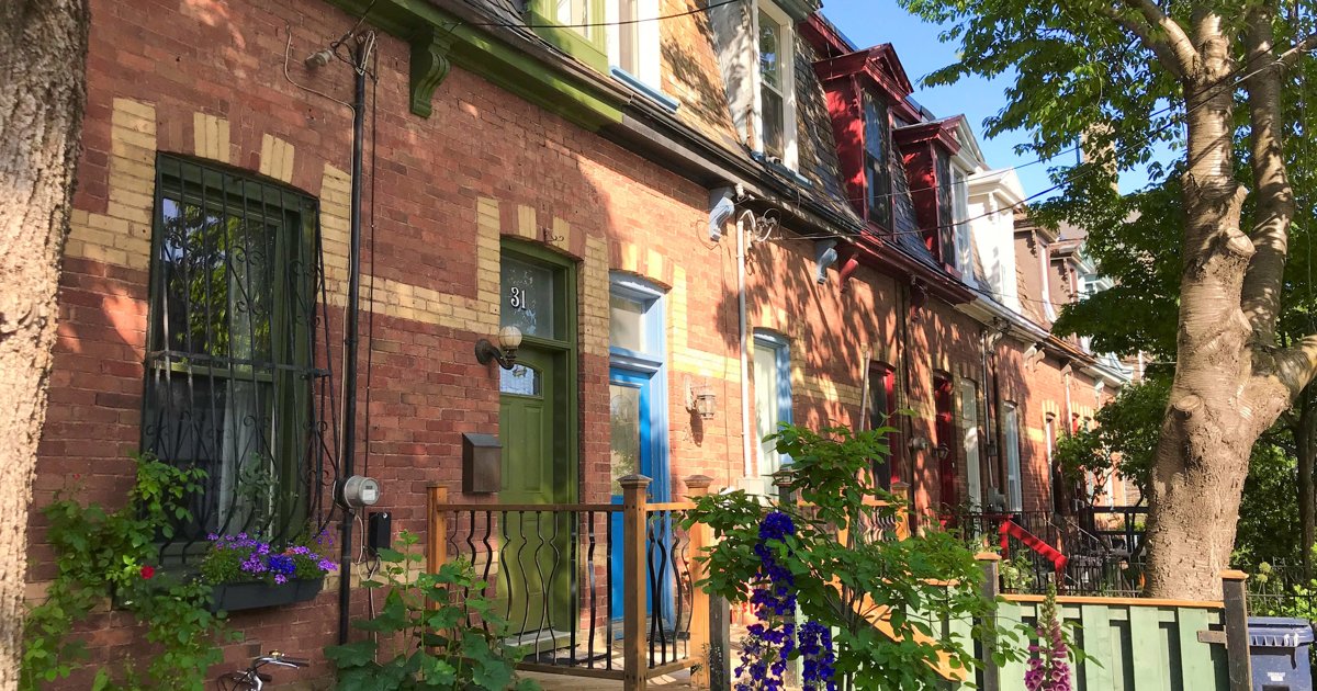A row of brick houses with gardens on Sackville Street in Corktown, Toronto