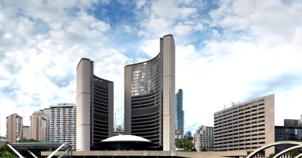 Toronto City Hall towers and council chamber at Nathan Phillips Square under a cloudy sky