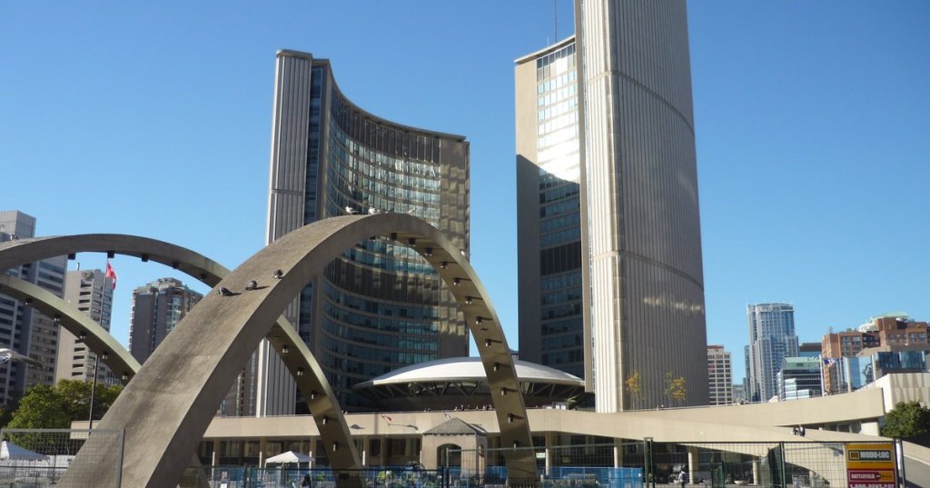 Toronto City Hall towers behind the arches of Nathan Phillips Square