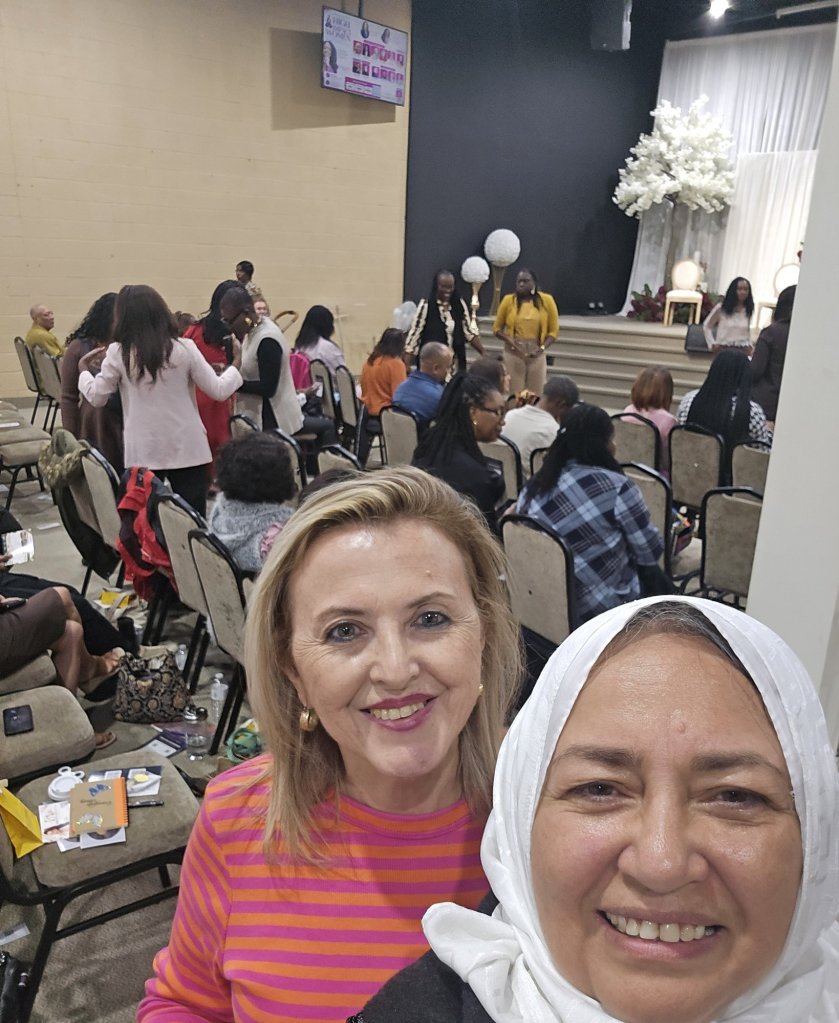 Bahira Abdulsalam takes a selfie with a supporter in a busy event hall in Toronto